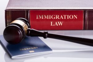 Close-up Of Gavel And Passport In front of law immigration Book