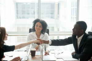 people shaking hadns during mediation at lawyers desk